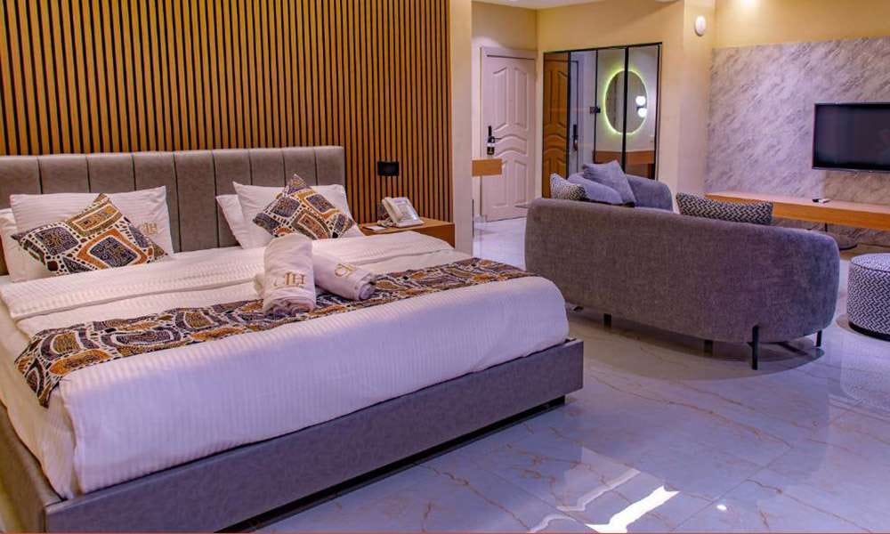 Country Lodge Hotel guestroom with bed sofa TV wall and custom furniture