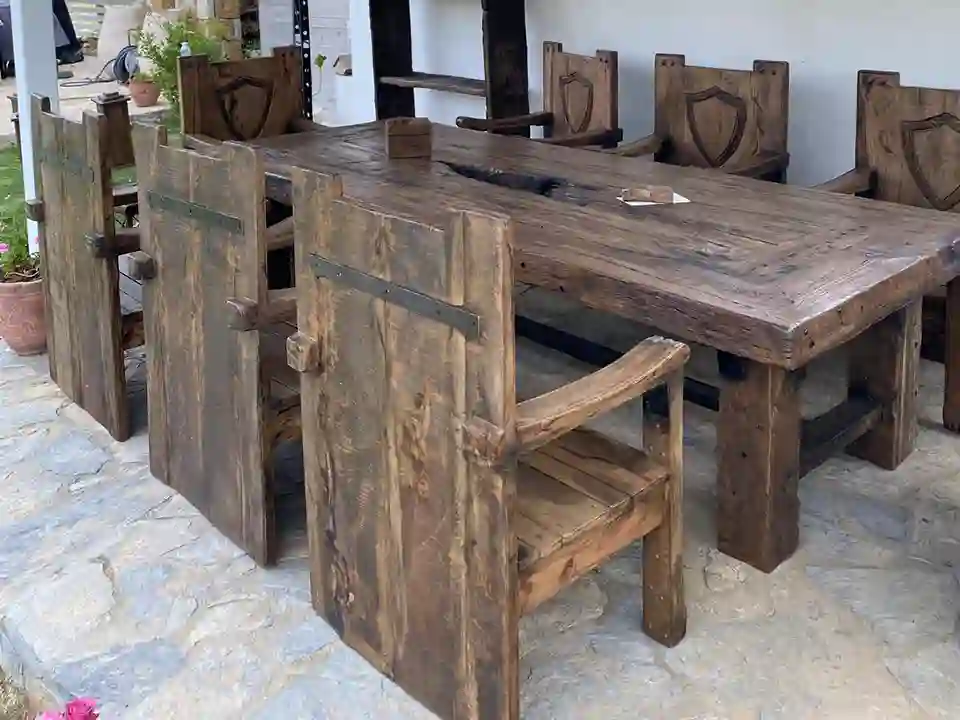 Large reclaimed wood dining table with high-back chairs for hotel and restaurant interiors